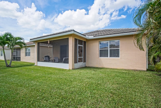 back of house featuring a sunroom and a yard