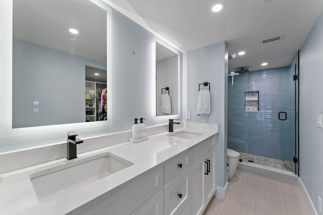 bathroom featuring vanity, toilet, and a shower with shower door