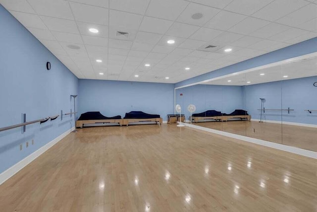 exercise area featuring hardwood / wood-style flooring and a paneled ceiling