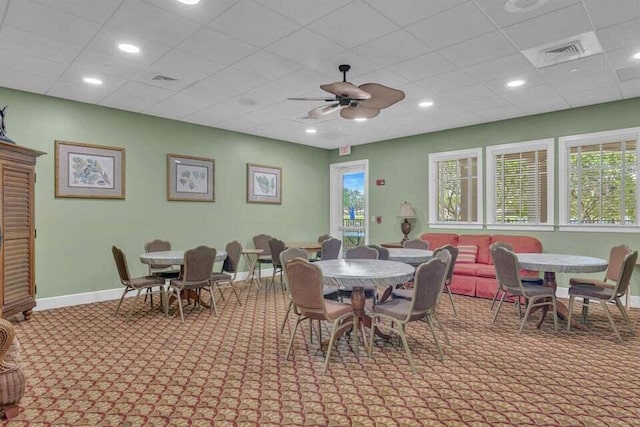 carpeted dining space with ceiling fan