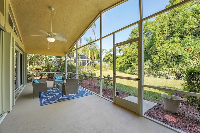 sunroom with ceiling fan and lofted ceiling