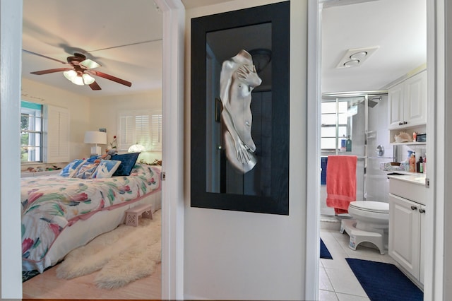 bedroom with light tile patterned flooring, ceiling fan, and a closet