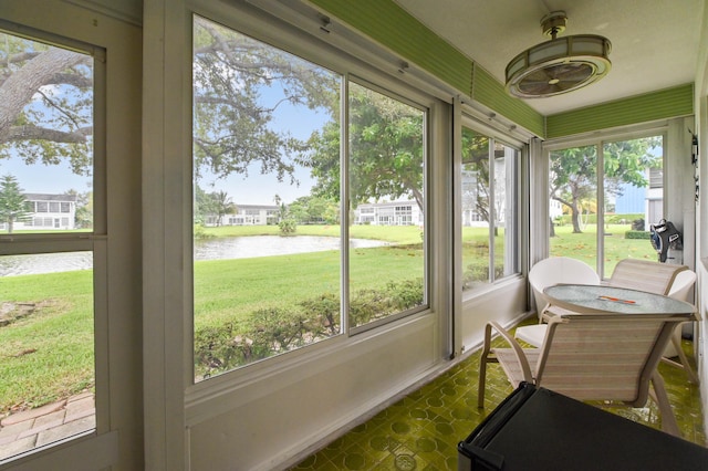 sunroom featuring a water view and a healthy amount of sunlight