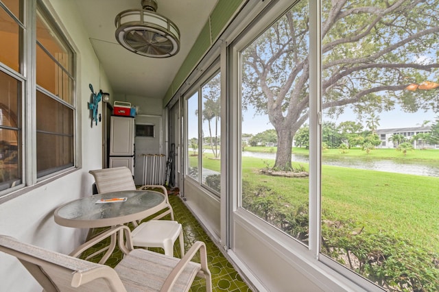 sunroom / solarium featuring a water view and a healthy amount of sunlight