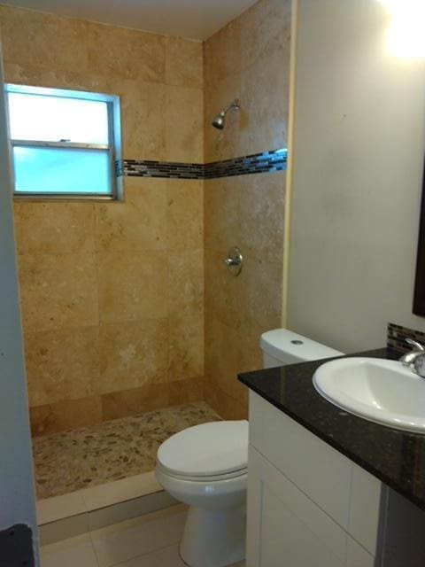 814 W Ocean Dr, Boynton Beach, FL 33426 - full bathroom with a sink, tiled shower, tile patterned floors, and toilet