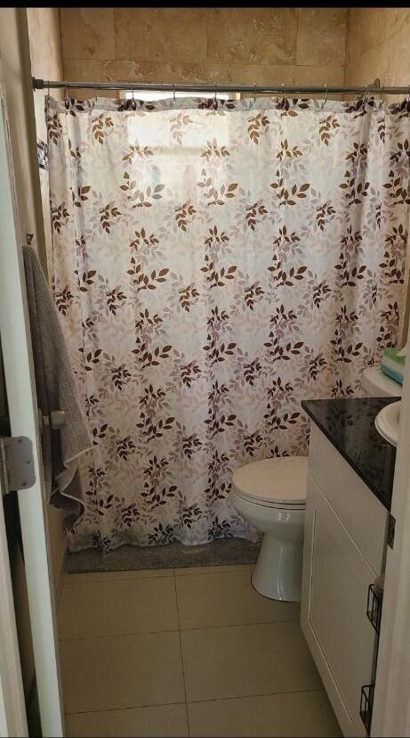 bathroom featuring tile patterned flooring, vanity, and toilet