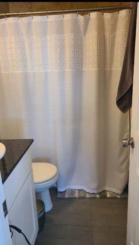 bathroom featuring tile patterned floors, vanity, and toilet