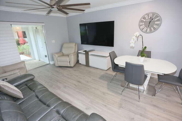 living room featuring ornamental molding, light wood-type flooring, and ceiling fan