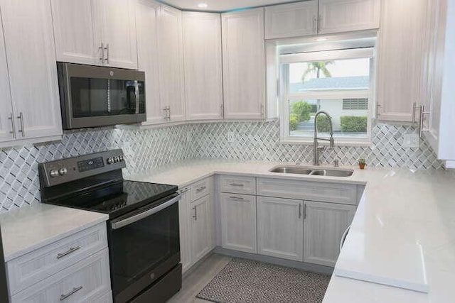 kitchen featuring appliances with stainless steel finishes, sink, and decorative backsplash