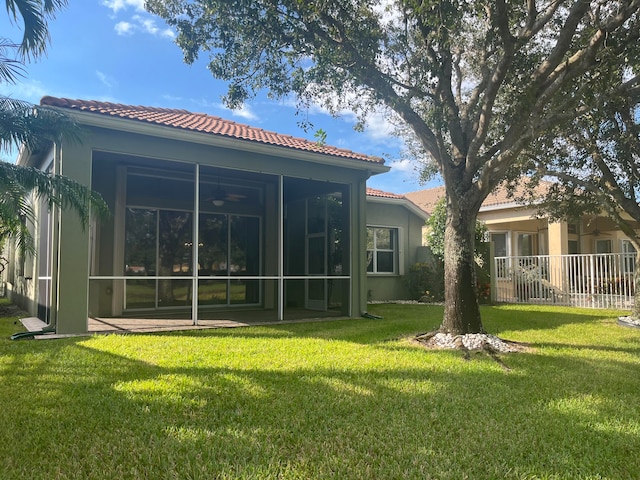 back of house featuring a lawn and a sunroom