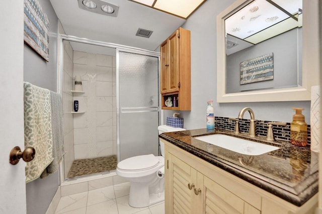 bathroom with vanity, toilet, and a shower with door