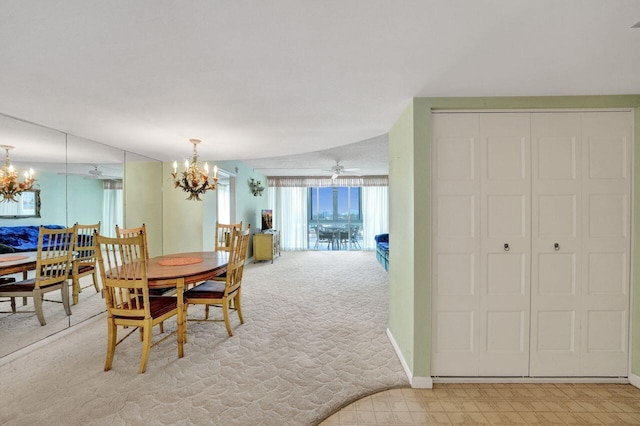 carpeted dining space with ceiling fan with notable chandelier and lofted ceiling