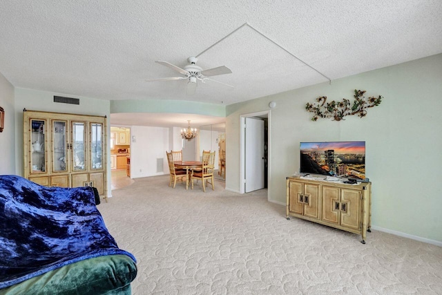 living room with ceiling fan with notable chandelier, a textured ceiling, and light colored carpet