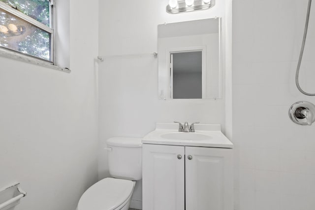 bathroom featuring tiled shower, vanity, and toilet