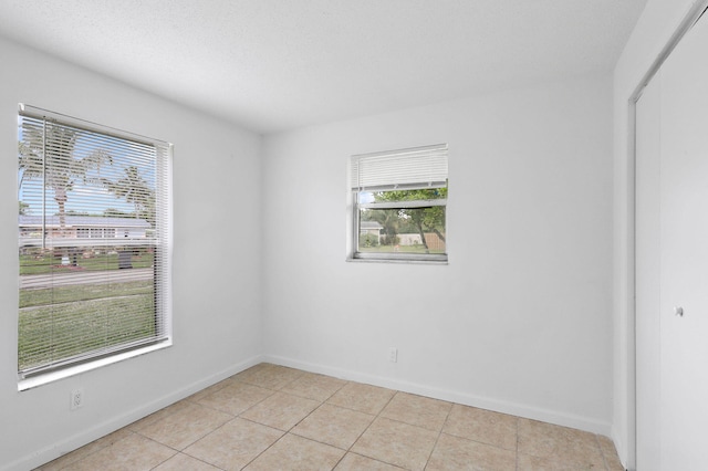 tiled empty room with a textured ceiling