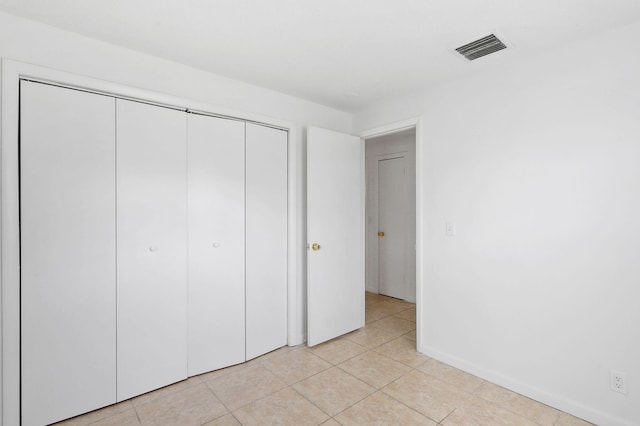 unfurnished bedroom with light tile patterned flooring and a closet