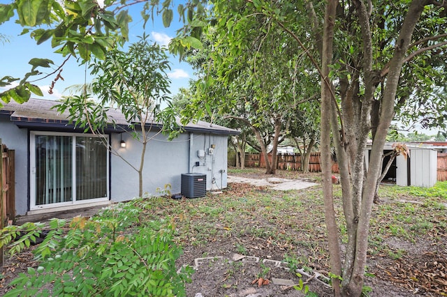 view of yard with central AC unit and a storage shed