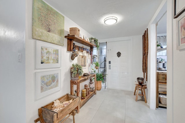 hallway with a textured ceiling and light tile patterned floors