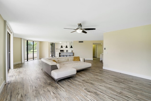 living room featuring ceiling fan and light hardwood / wood-style flooring