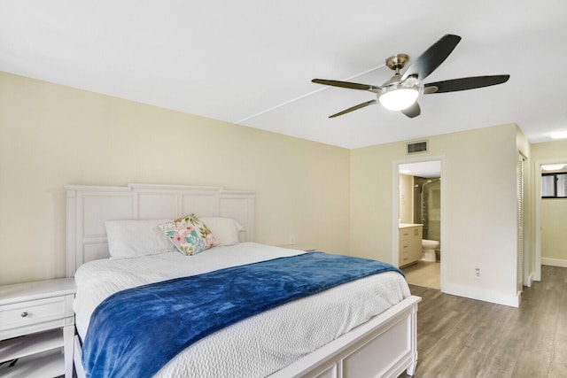 bedroom featuring ensuite bath, light hardwood / wood-style floors, and ceiling fan