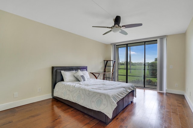 bedroom featuring ceiling fan, a wall of windows, dark hardwood / wood-style floors, and access to outside