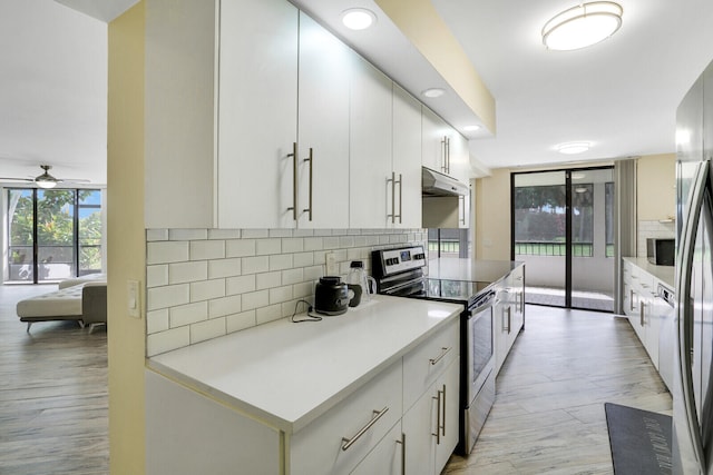 kitchen featuring appliances with stainless steel finishes, white cabinetry, tasteful backsplash, light wood-type flooring, and ceiling fan