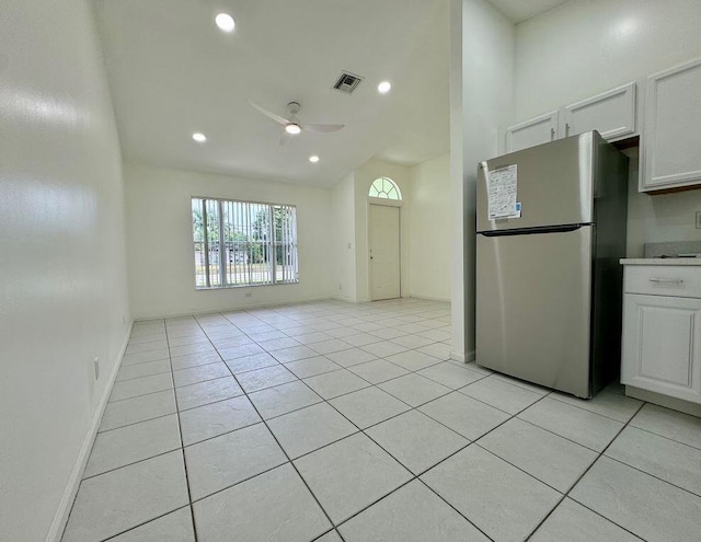 kitchen with stainless steel refrigerator, light tile patterned flooring, ceiling fan, and white cabinets