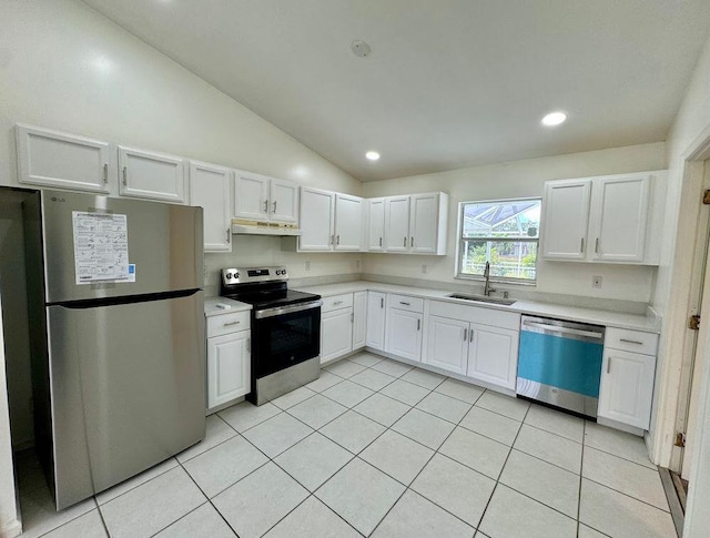 kitchen featuring light tile patterned flooring, sink, lofted ceiling, white cabinetry, and appliances with stainless steel finishes