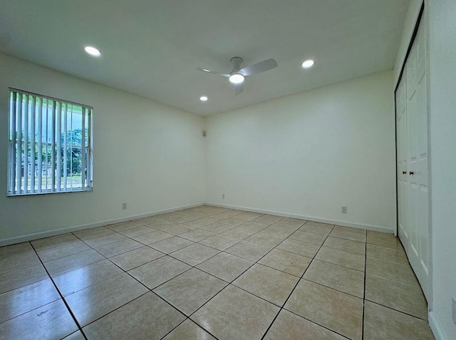 tiled spare room with ceiling fan