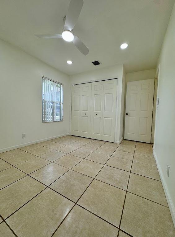 unfurnished bedroom featuring a closet, ceiling fan, and light tile patterned flooring