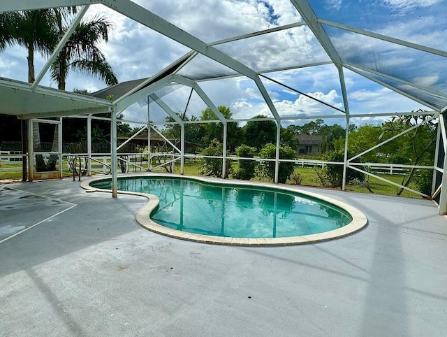 view of swimming pool featuring a patio and a lanai