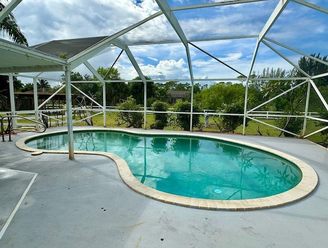 view of swimming pool with a lanai and a patio area