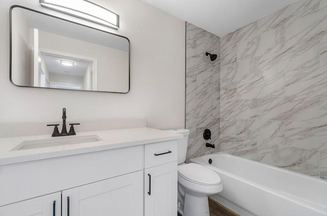 full bathroom featuring hardwood / wood-style floors, tiled shower / bath combo, toilet, and vanity