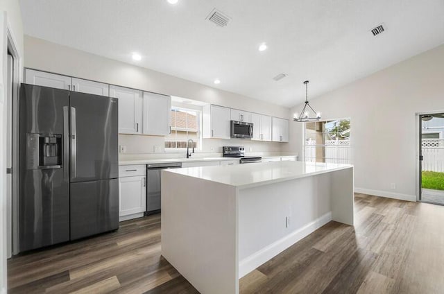 kitchen with white cabinetry, a kitchen island, pendant lighting, and appliances with stainless steel finishes