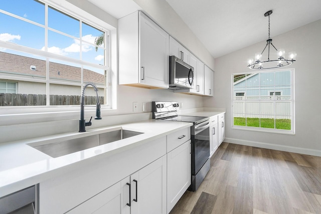 kitchen with white cabinetry, sink, a notable chandelier, and appliances with stainless steel finishes