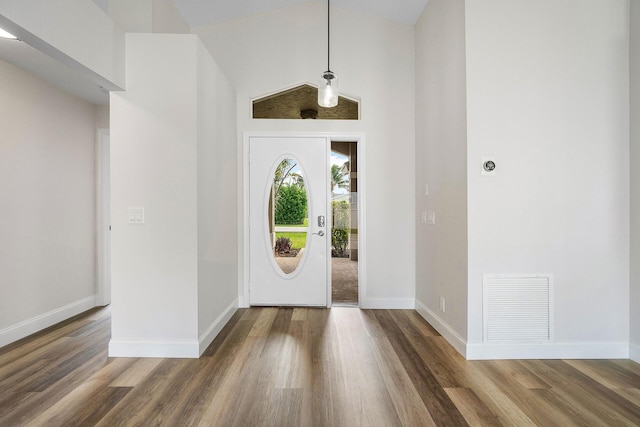 entrance foyer featuring dark wood-type flooring and high vaulted ceiling