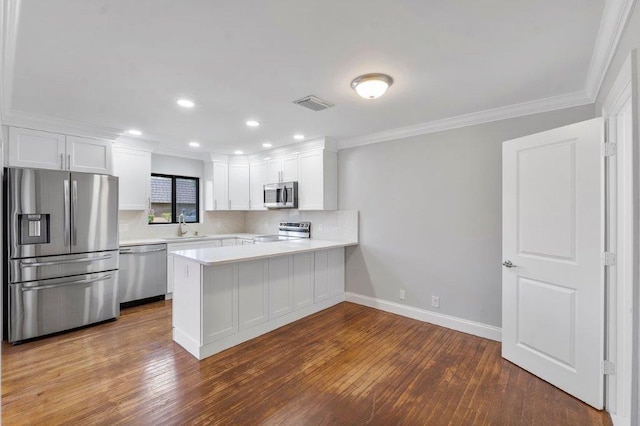 kitchen featuring kitchen peninsula, dark wood-type flooring, stainless steel appliances, and white cabinets