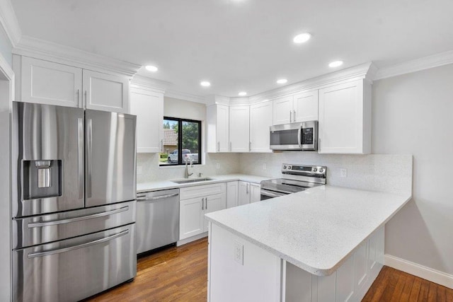 kitchen featuring white cabinets, backsplash, stainless steel appliances, dark hardwood / wood-style floors, and sink