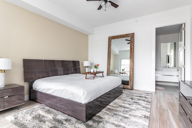 bedroom with light wood-type flooring, ensuite bath, and ceiling fan