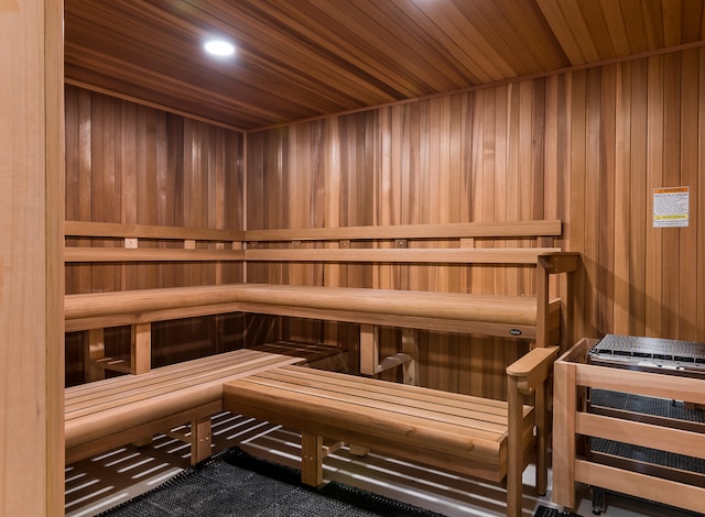 view of sauna / steam room featuring wooden ceiling and wooden walls