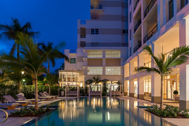 pool at twilight with a patio area