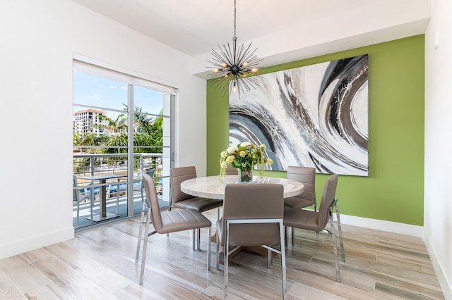 dining space featuring light wood-type flooring and a chandelier