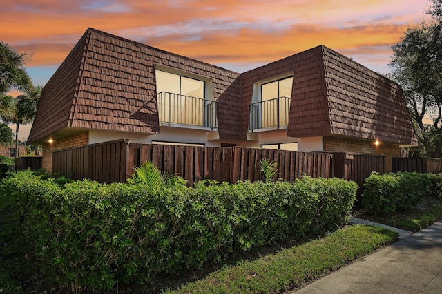 property exterior at dusk with a balcony