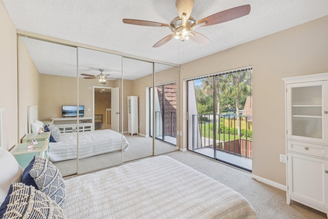 bedroom featuring a closet, light colored carpet, access to outside, and a textured ceiling