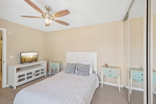 bedroom featuring ceiling fan, a textured ceiling, and carpet