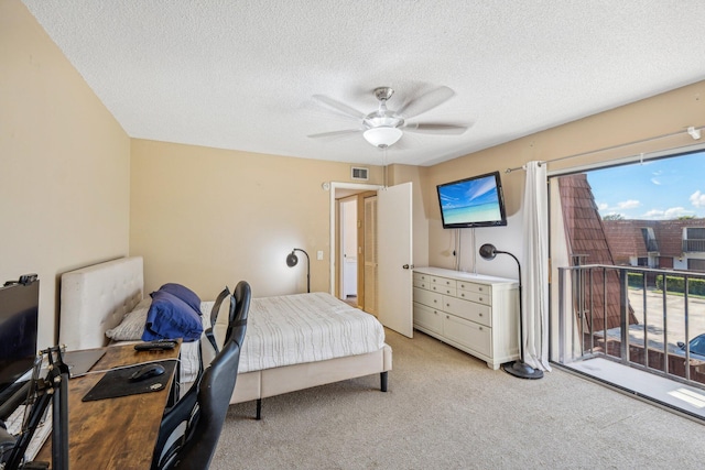 carpeted bedroom with ceiling fan and a textured ceiling