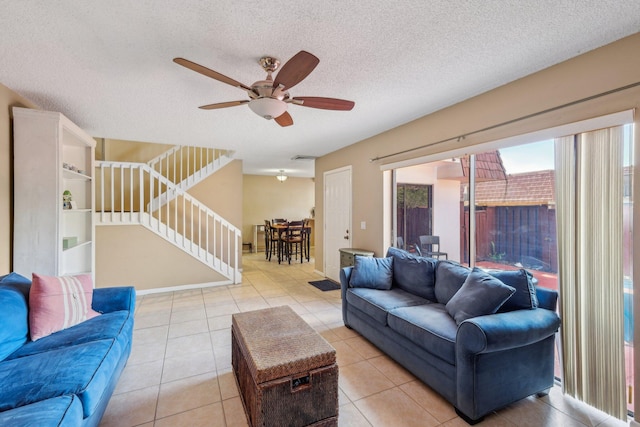 tiled living room featuring a textured ceiling and ceiling fan