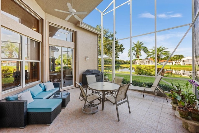 sunroom / solarium featuring a water view and ceiling fan