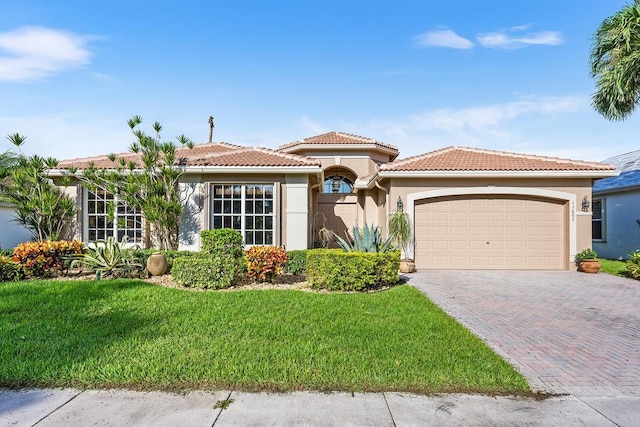 mediterranean / spanish-style house featuring a front yard and a garage