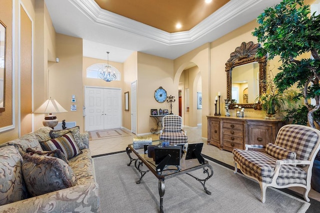 sitting room featuring an inviting chandelier, a tray ceiling, and ornamental molding